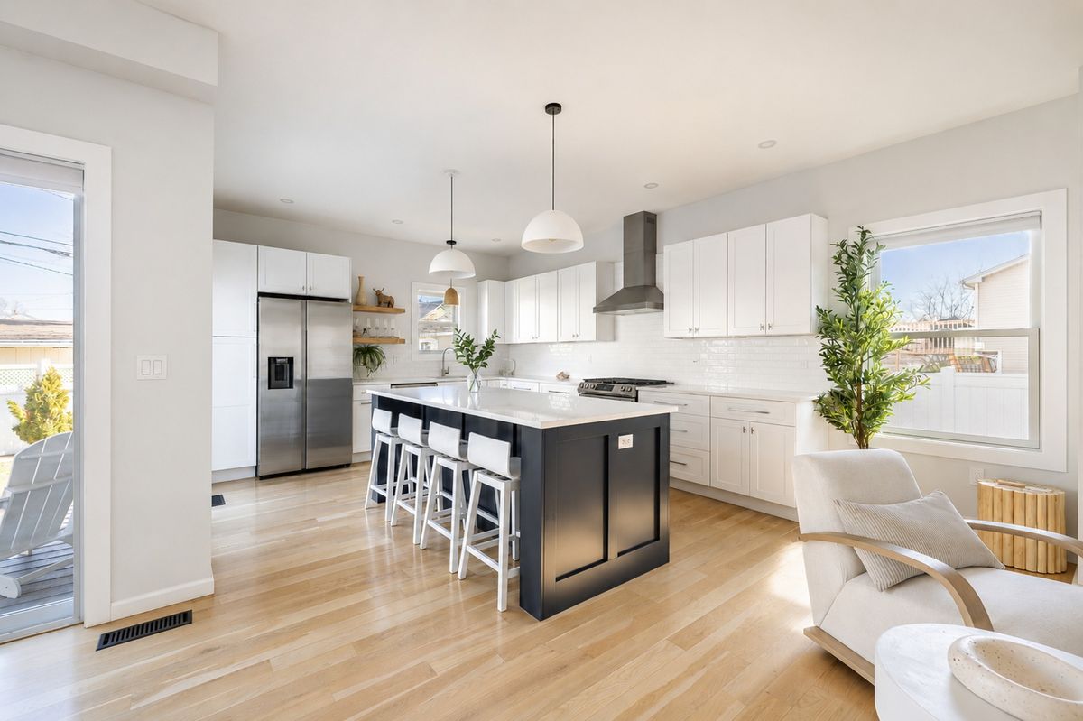Chef's kitchen with quartz island and custom shaker cabinetry.